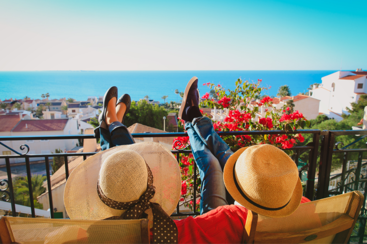 two people facing water relaxing on vacation