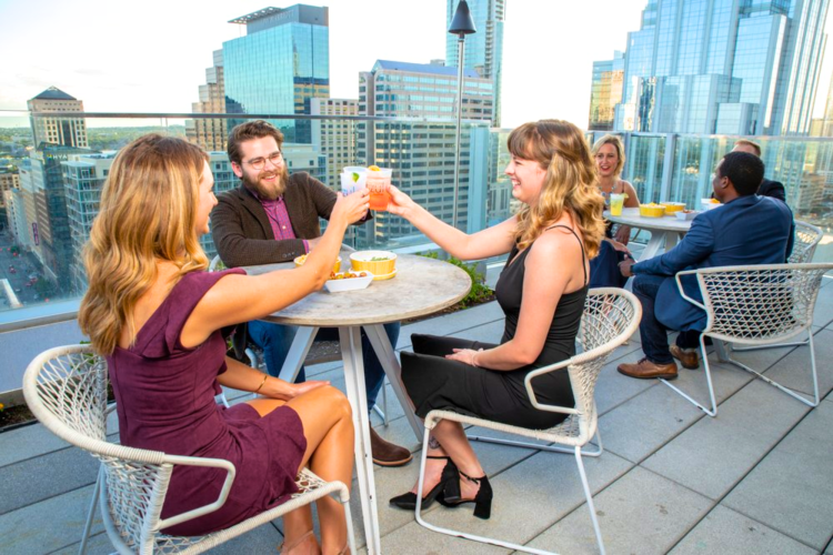 People enjoying cocktails at a rooftop bar in Austin.