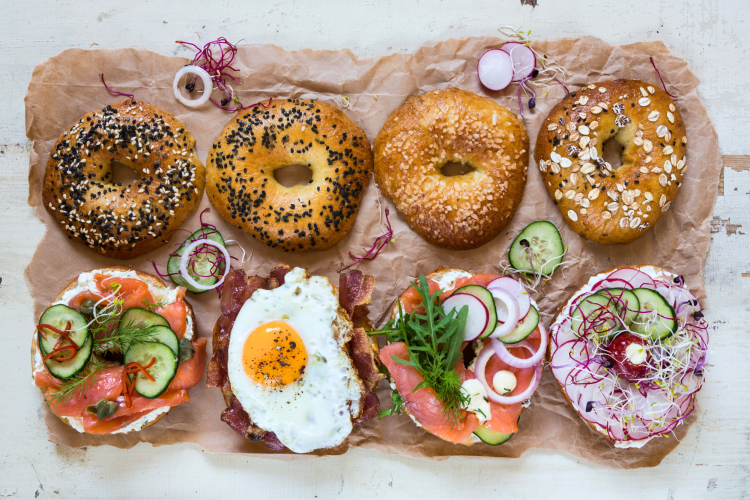 different flavored bagels with different colorful toppings