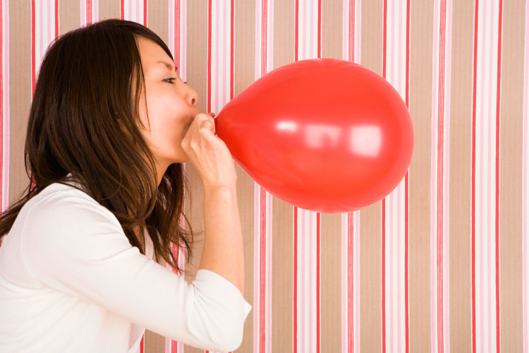 Learn how to make a balloon arch by blowing up balloons.