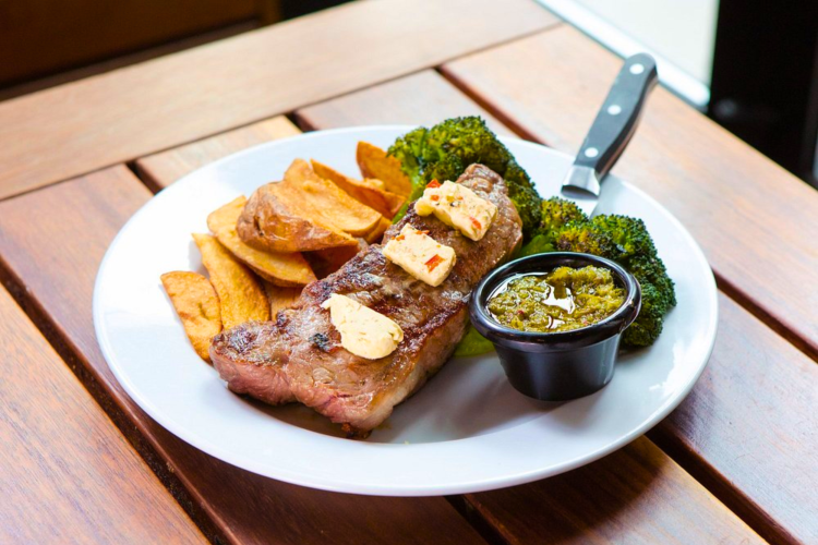 A juicy steak and fries are served at this rooftop restaurant in Boston.