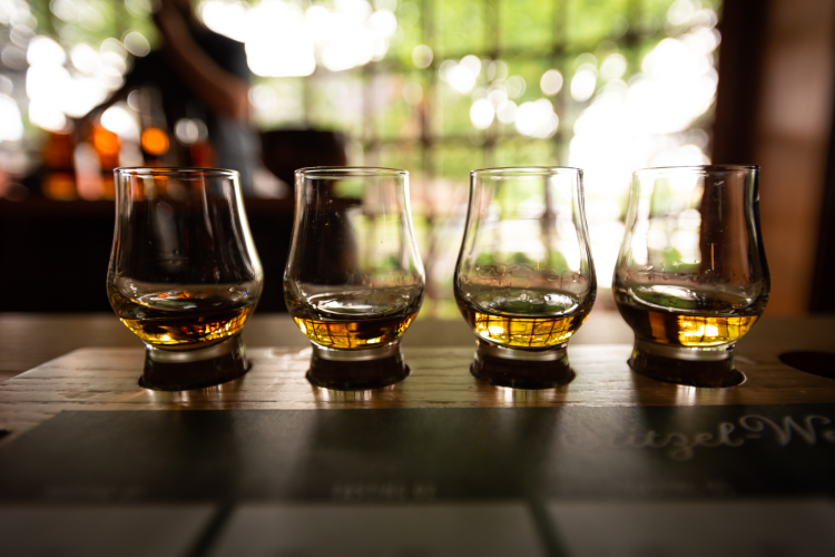 four bourbon tasting glasses arranged in a flight for tasting