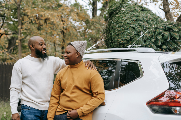 father and son standing by son's new car gift