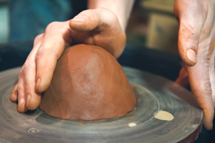 centering a slab of clay on pottery wheel