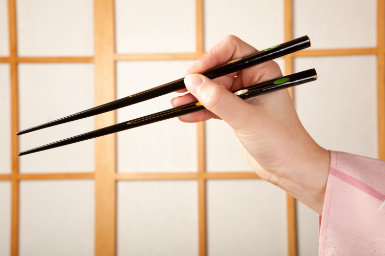 hands holding set of chopsticks