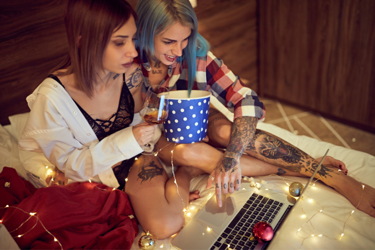 two people watching holiday movie together at home on laptop