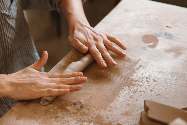 hand rolling clay to create a coil