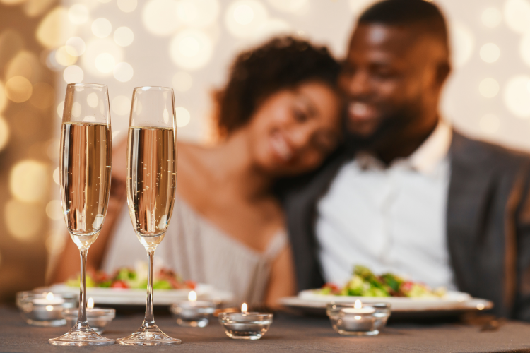 romantic couple cozied up at restaurant with champagne