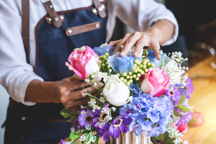 hands arranging flowers in a vase