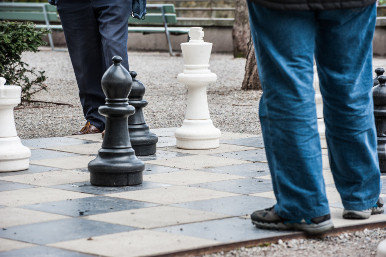 people walking on giant chess board