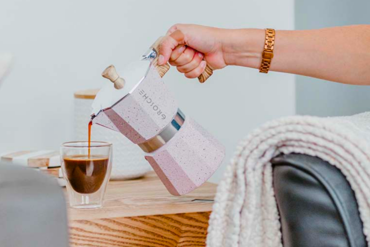 hand pouring coffee from a coffee pot
