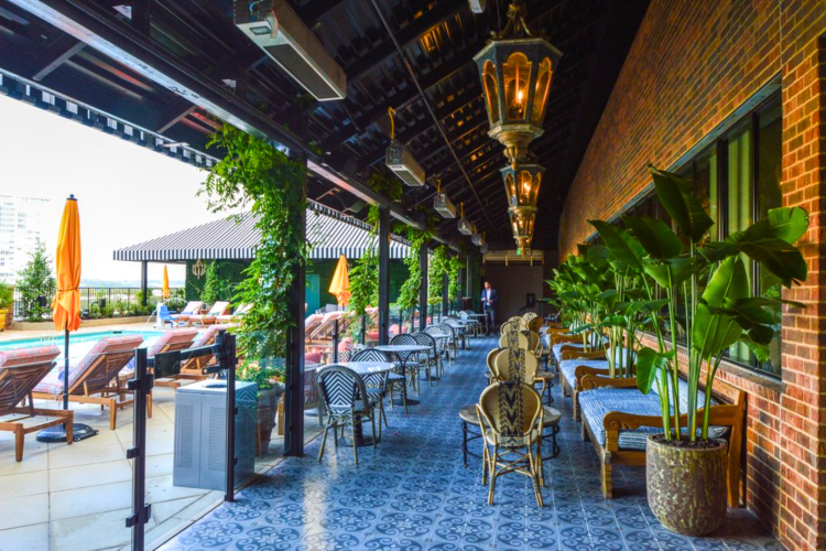 This rooftop outdoor space features a bar and a swimming pool, making a beautiful rooftop bar in Austin.