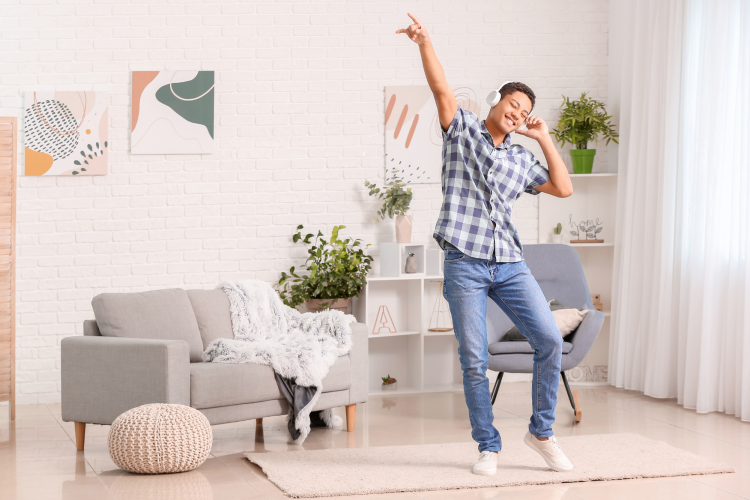 teen boy dancing in room wearing headphones