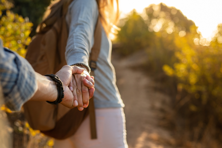 couple holding hands while hiking