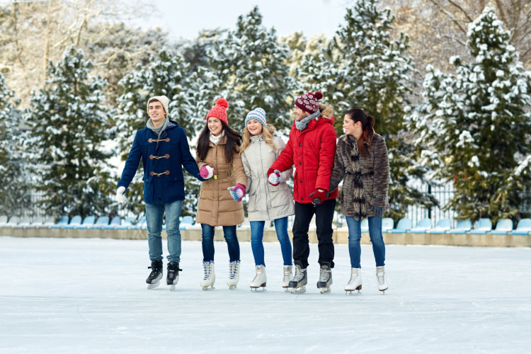group of friends ice skating together outdoors