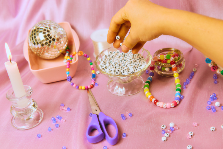 hand reaching for bowl of friendship bracelet beads