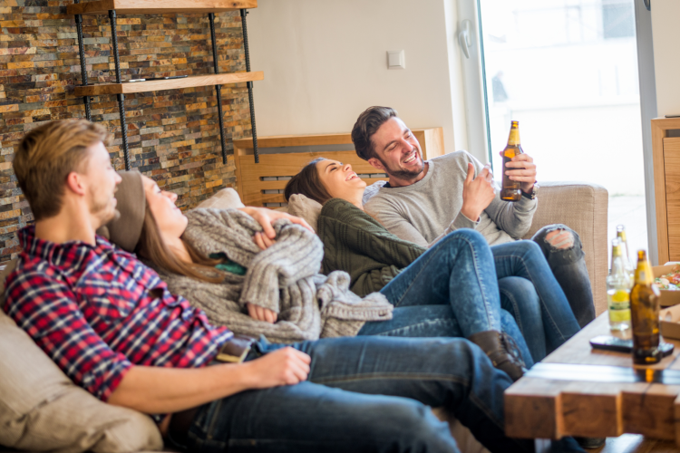 two couples drinking and watching movies at home