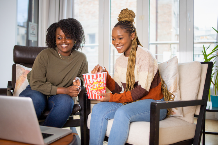 couple watching movie with popcorn at home on the couch