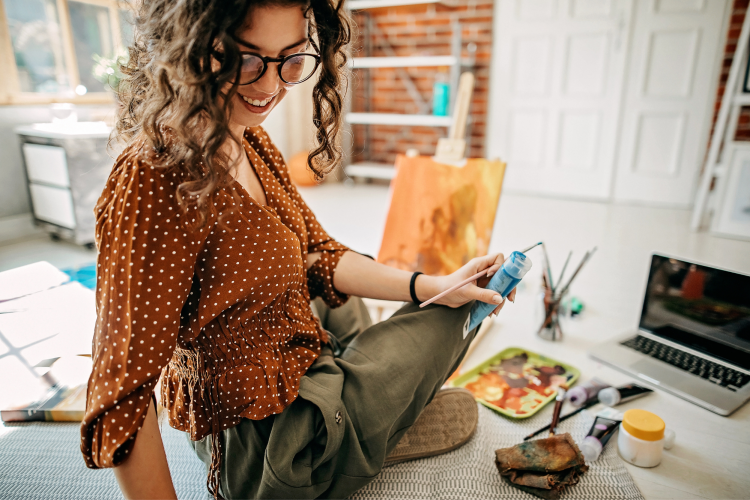 young woman taking an online painting class in her apartment