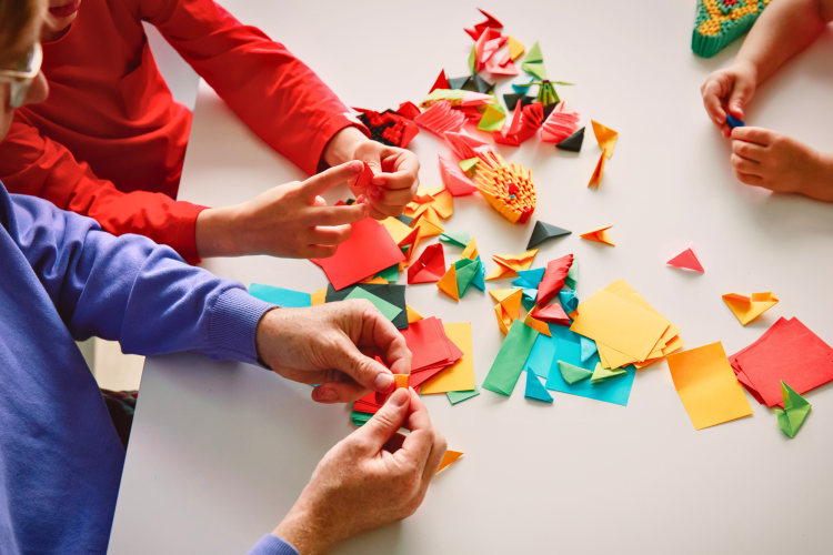 kids folding origami at table