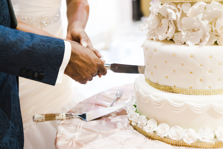 Cutting ornate wedding cake