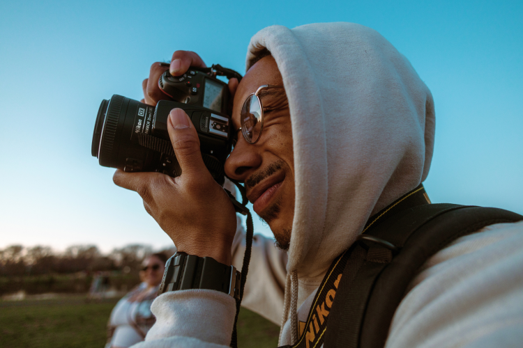 man taking photos outdoors with digital camera