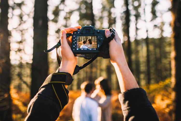 photographer pointing camera toward couple