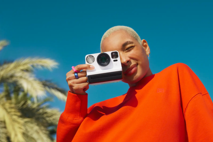 woman taking photo with vintage Polaroid camera