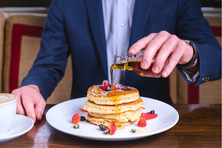 A stack of pancakes with strawberries, blueberries and syrup from this Restaurant in Back Bay, Boston