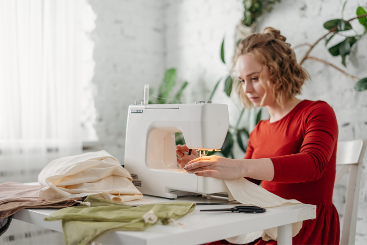 young woman with fabric on sewing machine