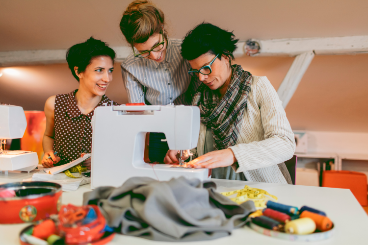 friends sewing fabric together in sewing class