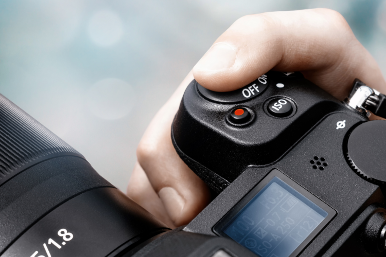 finger pressing the shutter button on camera