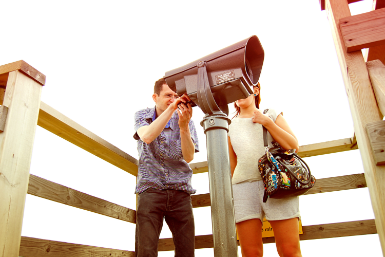 couple sightseeing through telescope