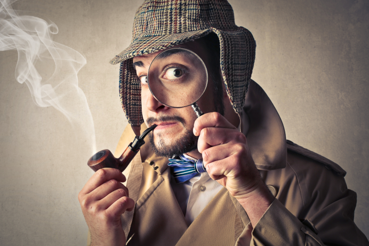 man dressed as detective with a magnifying glass