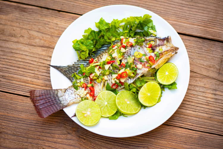 Steamed fish with salad and limes is a popular Chinese New Years food.