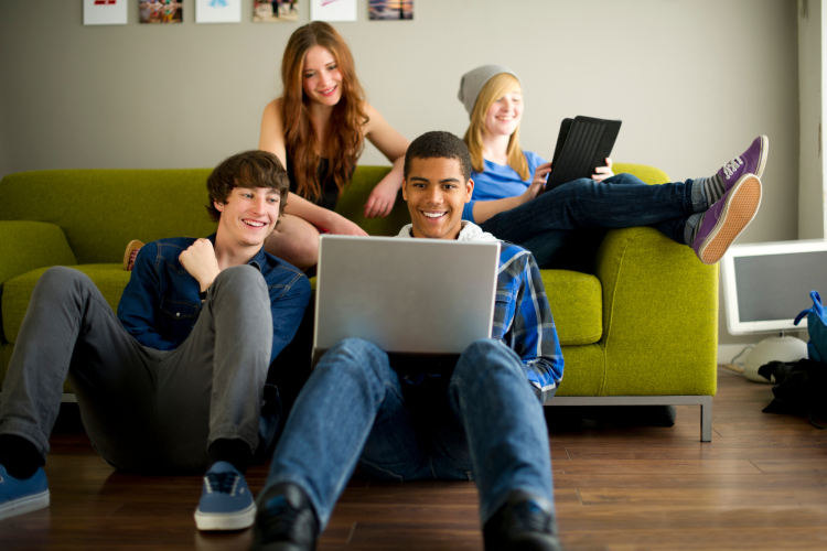 group of teens playing games on laptop