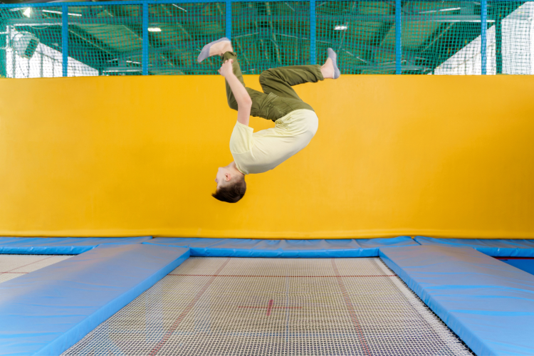 kid doing a flip at an indoor trampoline park