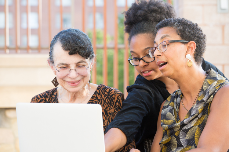 group of three older women playing games on laptop