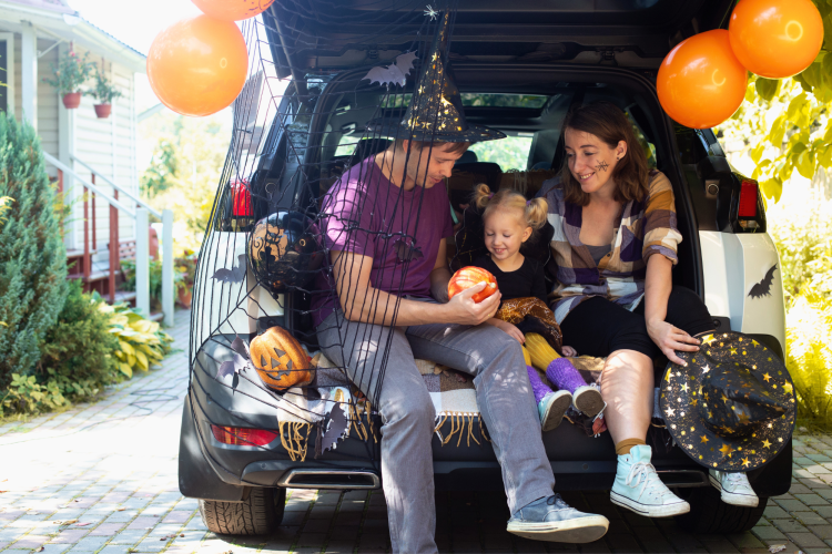 family in Halloween decorated car trunk