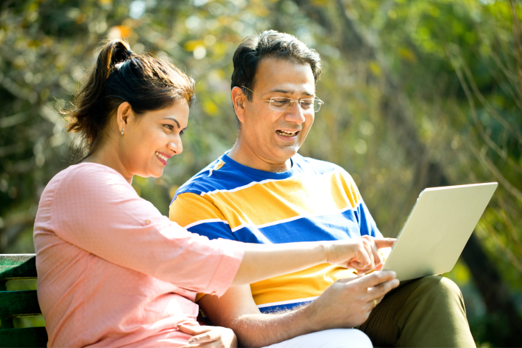 adult couple playing game on computer outdoors
