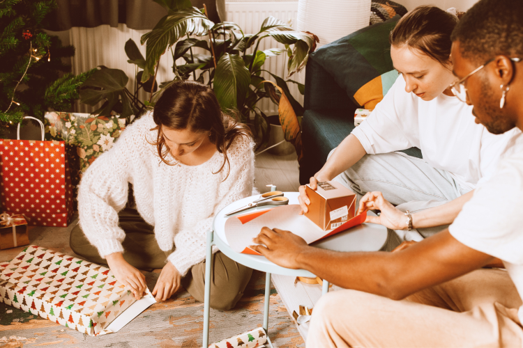 group of friends wrapping Christmas gifts together
