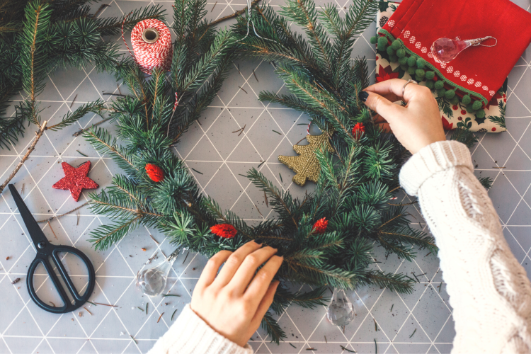hands assembling holiday wreath