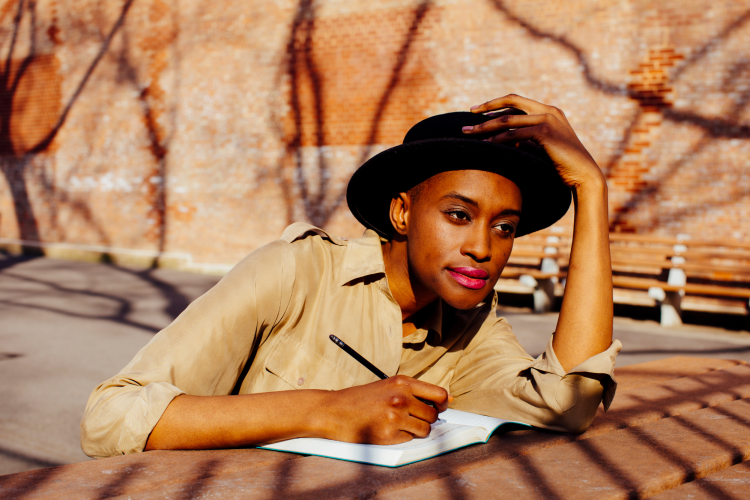 writer journaling on an outdoor table