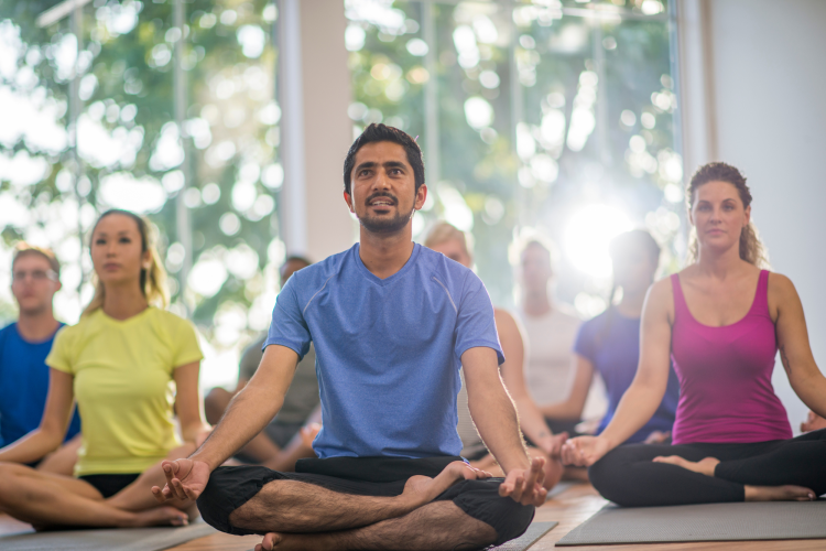 group of people meditating in yoga class