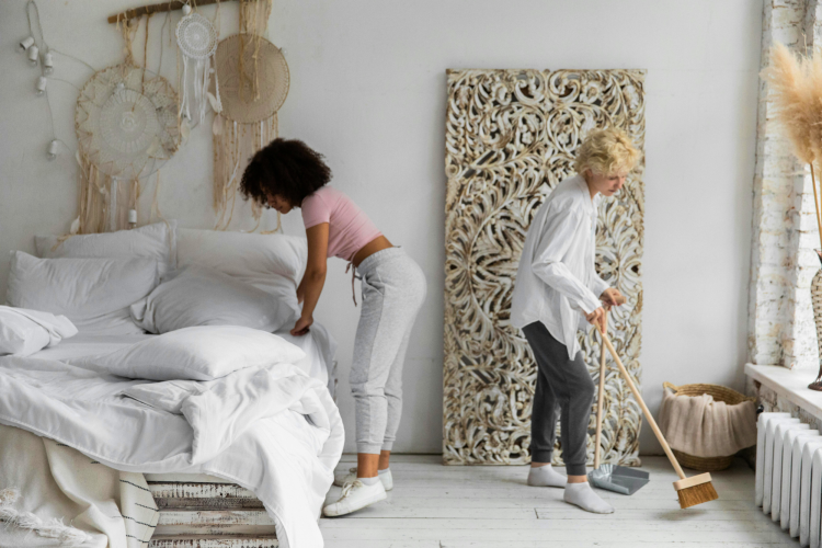 Diverse couple cleaning bedroom