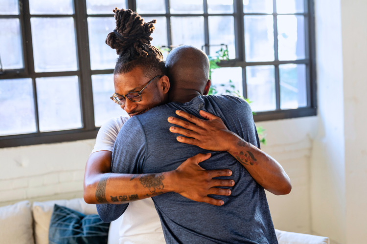 two men hugging compassionately