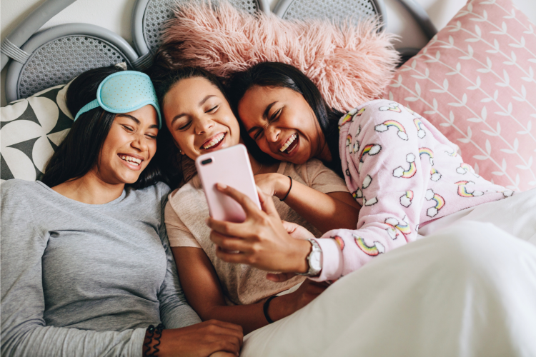 girls looking at a phone during a sleepover