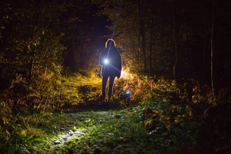 person holding a flashlight in the dark