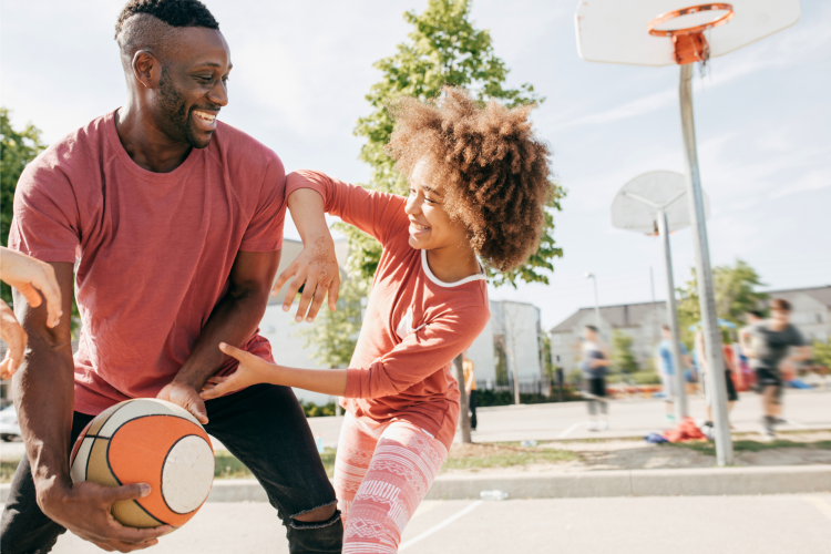 dad and daughter playing basketball