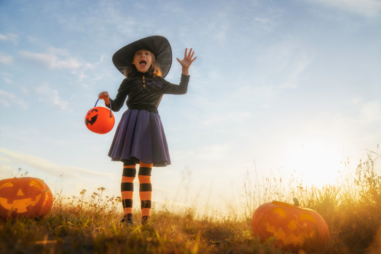 girl dressed as a witch for Halloween and screaming to give someone a fright